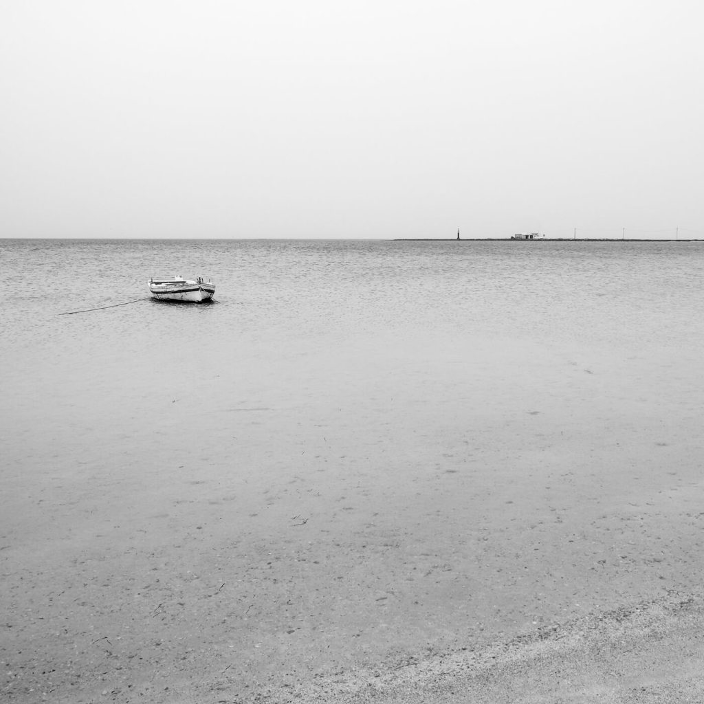 Photo en noir et blanc d'une barque sur la jetée à Kerkennah en Tunisie.