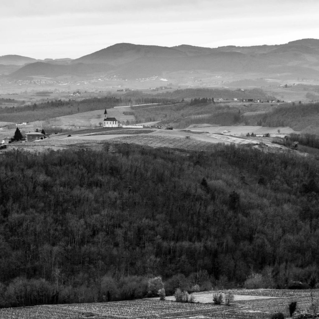 Photo en noir et blanc de la chapelle au loin à Saint-Laurent-d'Oingt dans le Rhône, en France.