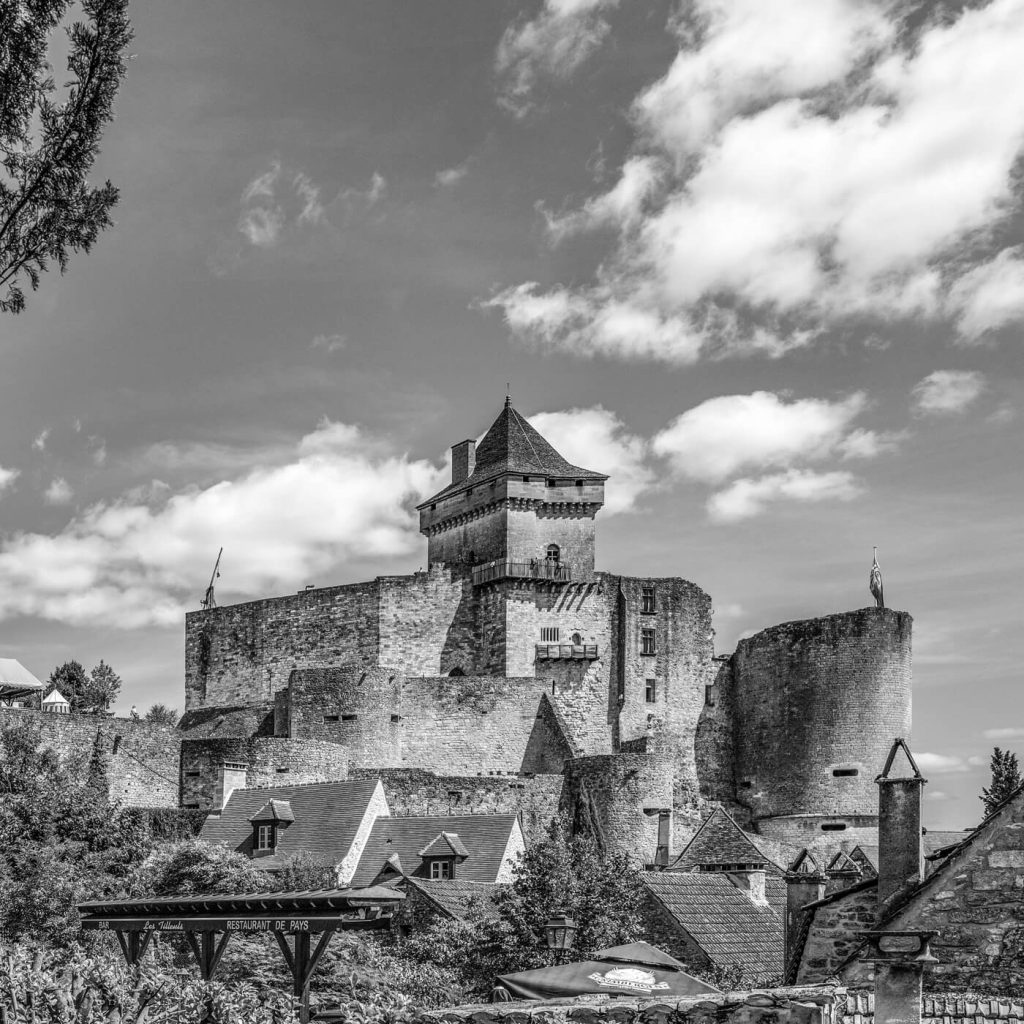 Photo en noir et blanc du château de Castelnaud en Dordogne, en France.