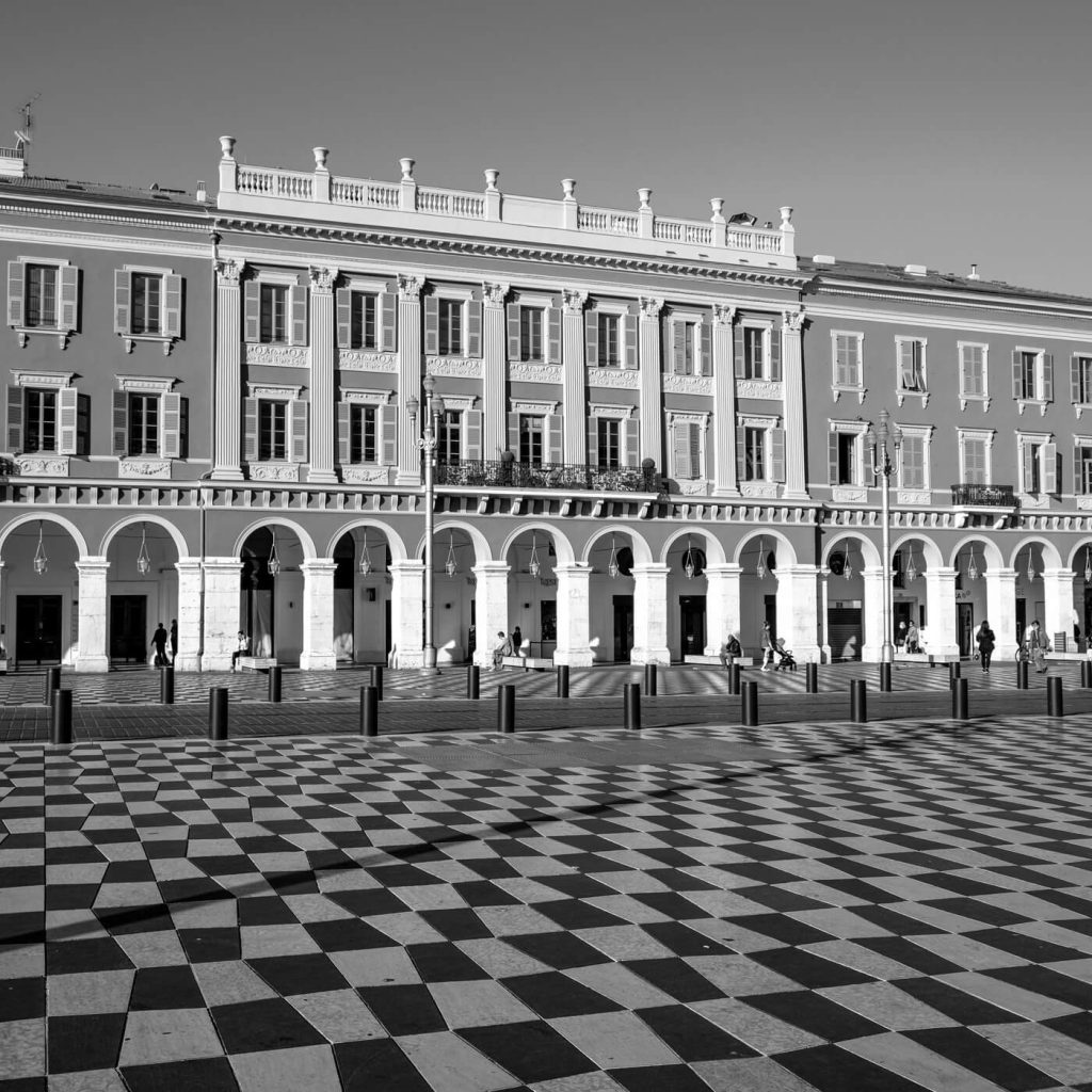 Photo en noir et blanc de la Place Masséna et de ses damiers géants à Nice, en France.