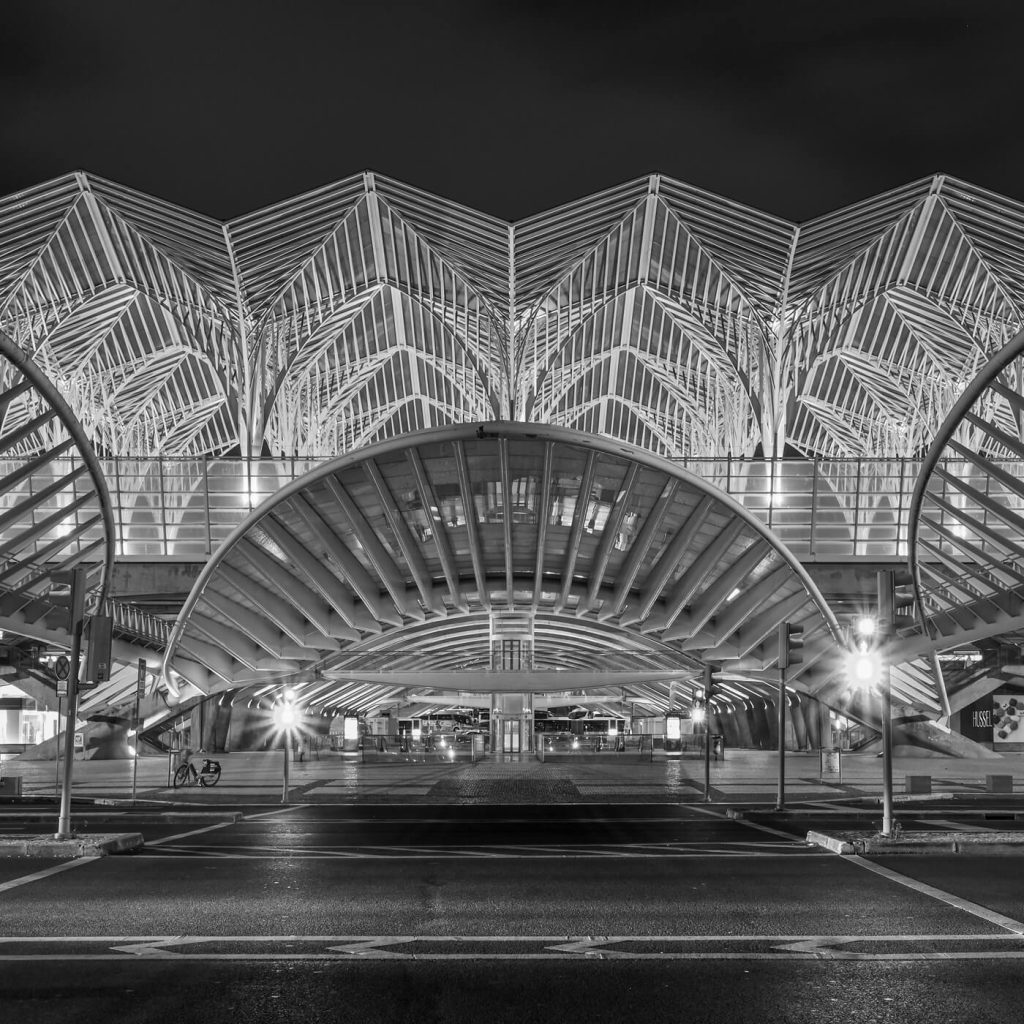 Photo en noir et blanc de l'entrée principale de la gare Oriente à Lisbonne.