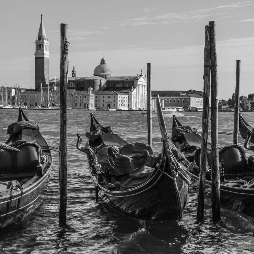 Photo en noir et blanc des gondoles et de l'église Saint-Georges à Venise.