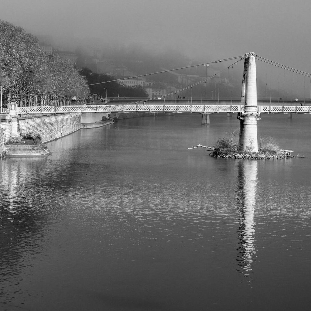 Photo en noir et blanc du Rhône et de la passerelle du Collège à Lyon.