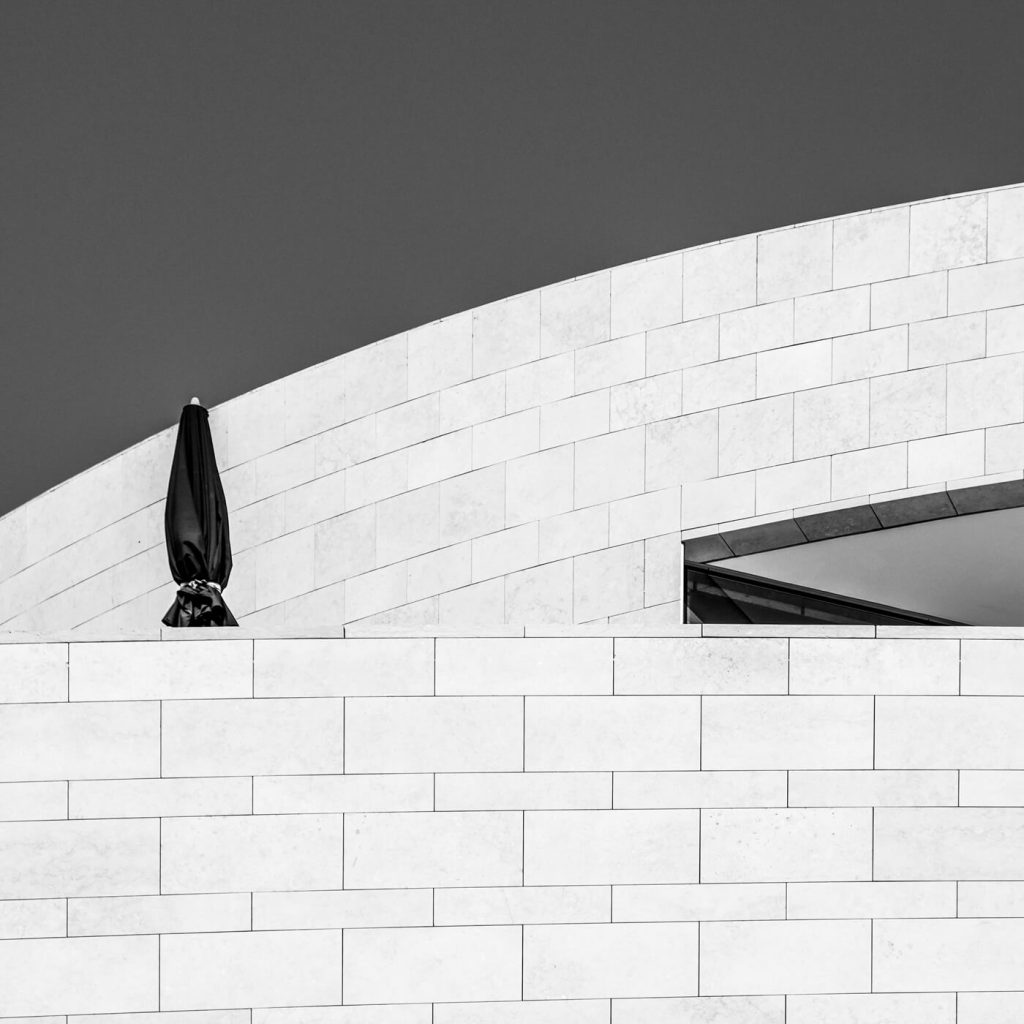 Photo en noir et blanc des murs d'un bâtiment avec un parasol fermé à Lisbonne.