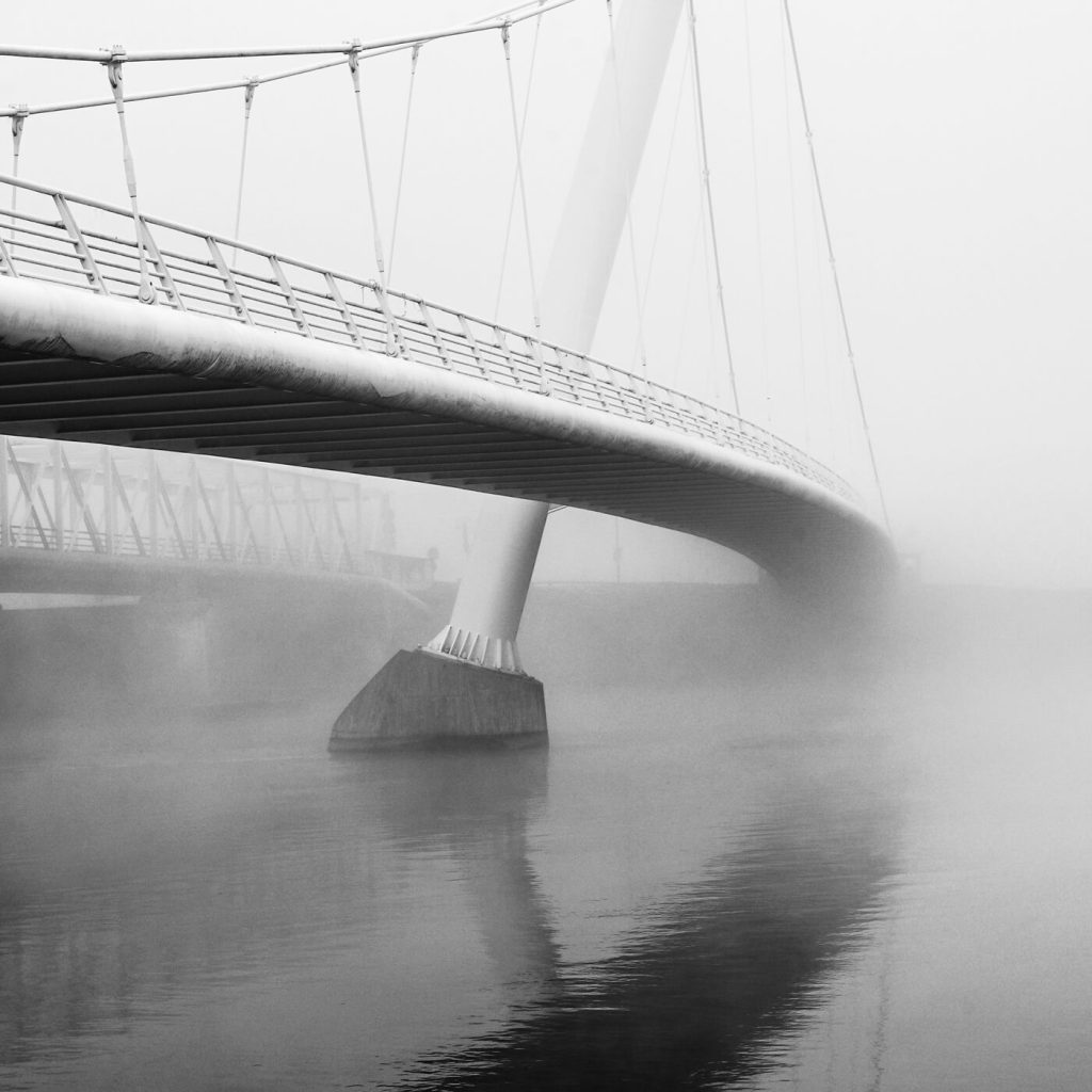 Photo en noir et blanc de la passerelle et du pont de Décines dans le Rhône.