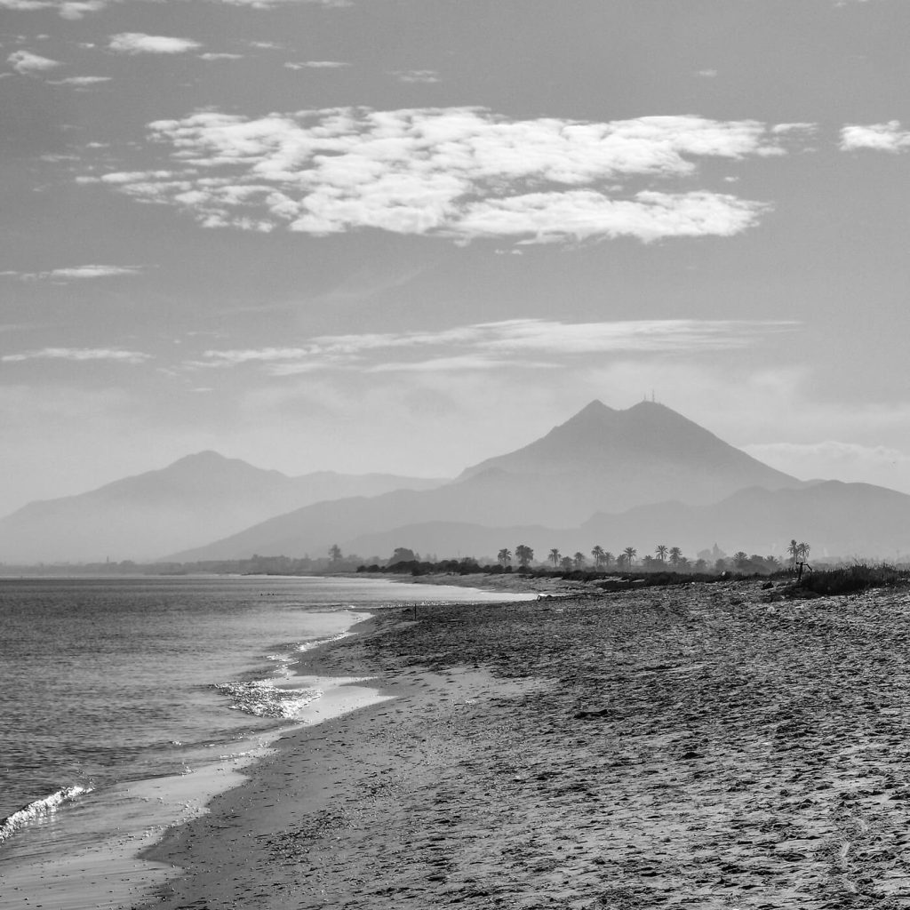 Photo en noir et blanc de la plage et du Djebel Boukornine à Radès, en Tunisie.