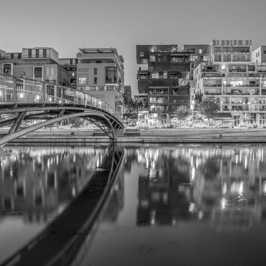 Photo en noir et blanc du pont sur la Darse et du quartier de la Confluence à Lyon.