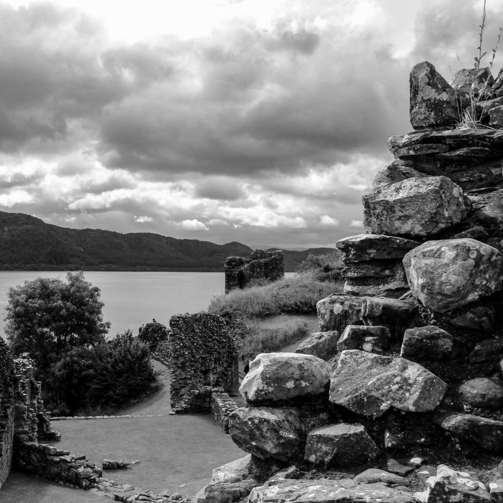 Photo en noir et blanc des ruines d'Urquhart près du Loch Ness en Écosse.